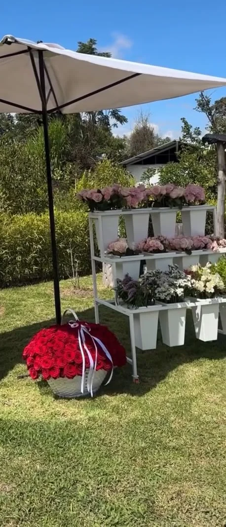 Montaje del Flower Bar con flores y canasta bajo una sombrilla