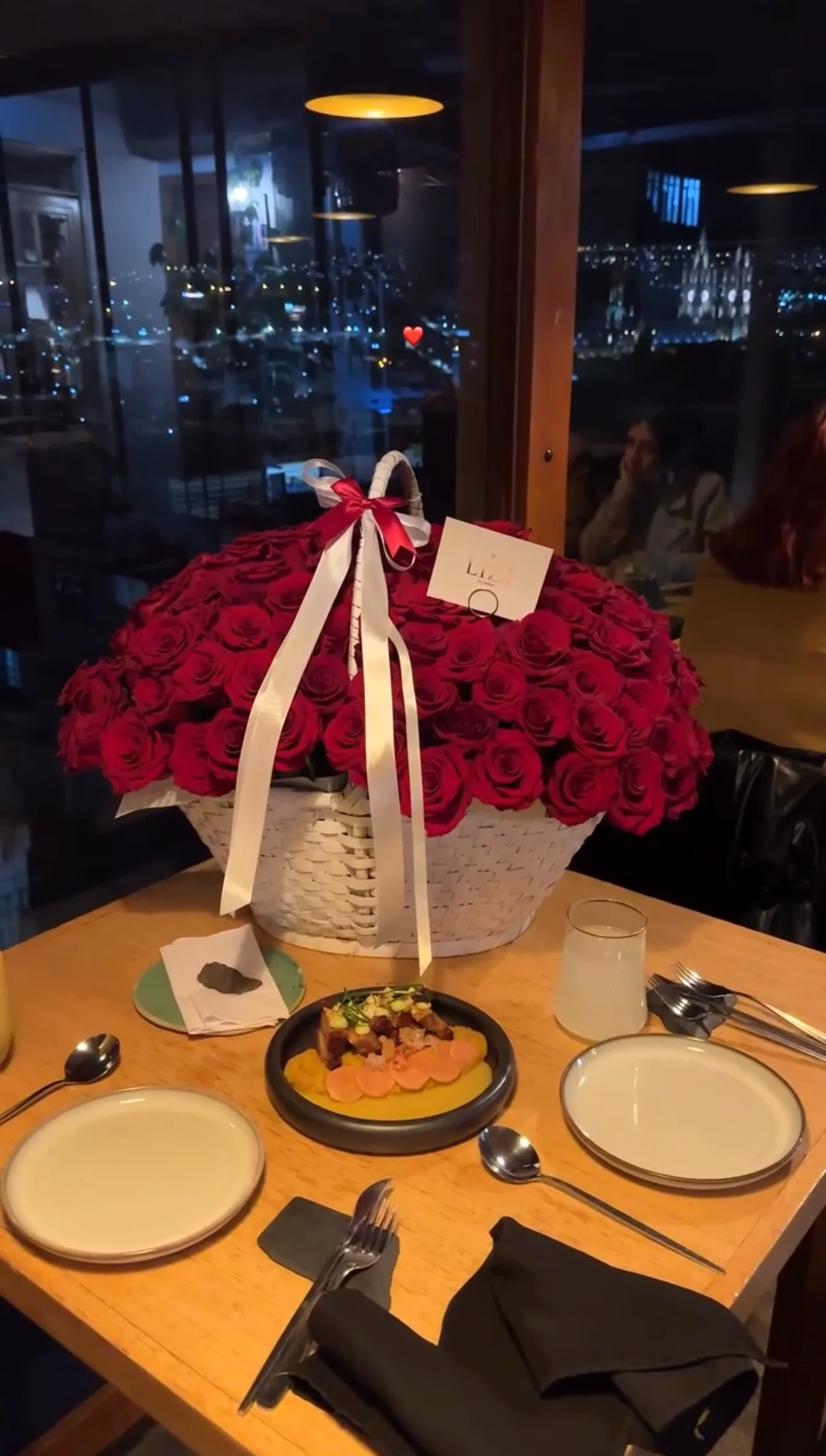 Canasta de rosas rojas sobre una mesa de celebración