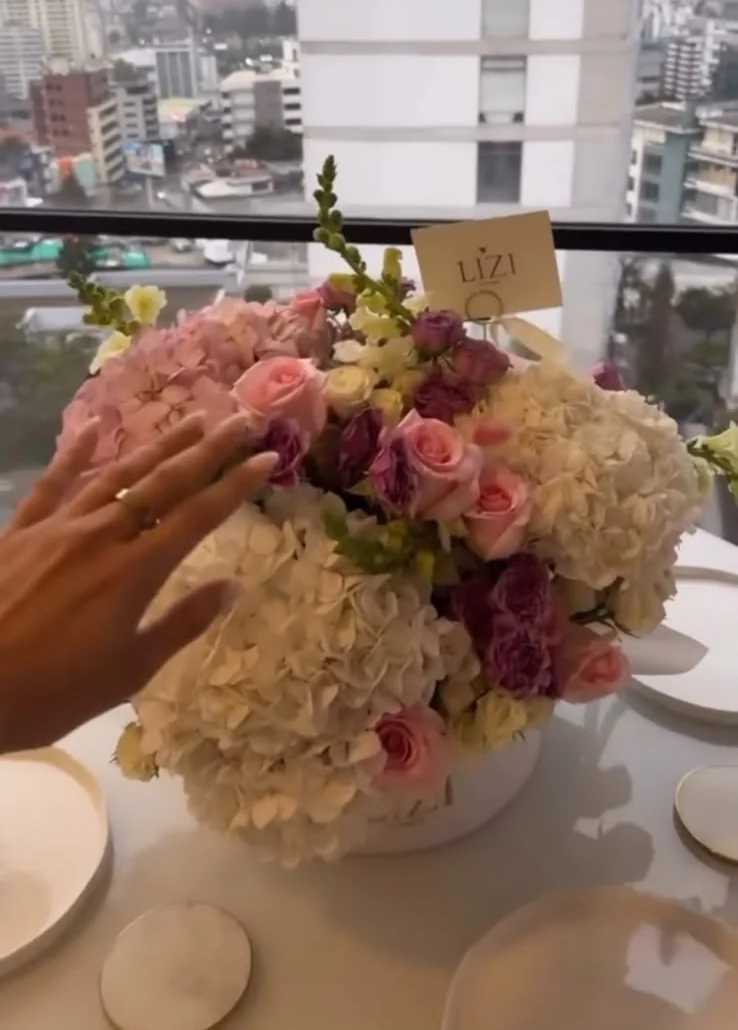 Detalle de un arreglo pastel de hortensias y rosas junto a una ventana
